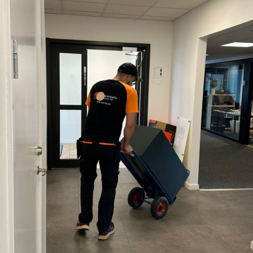 Medarbetare på Uppsalaflyttfirma hjälper till att flytta en kassaskåp när företagsflytt utförs i Uppsala - Uppsalaflyttfirma